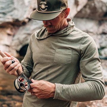 guy wearing moss green shirt holding fishing rod
