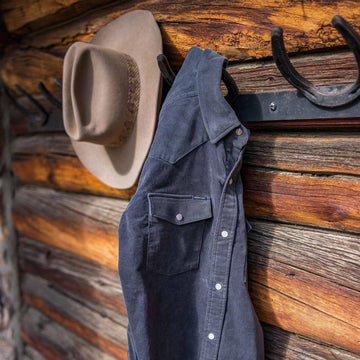 navy corduroy pearl snap shirt hanging on hook