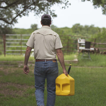 man walks with gasoline while wearing tan short sleeve shirt
