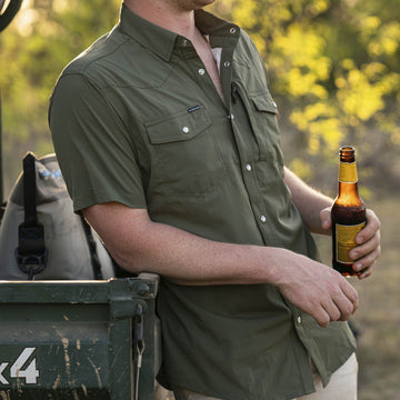 picture of guy wearing moss green western shirt leaning against tailgate