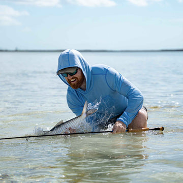 man with fish wearing sky blue hoodie