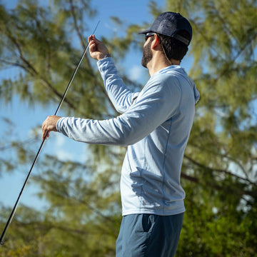 man holding fishing rod wearing sky blue hoodie