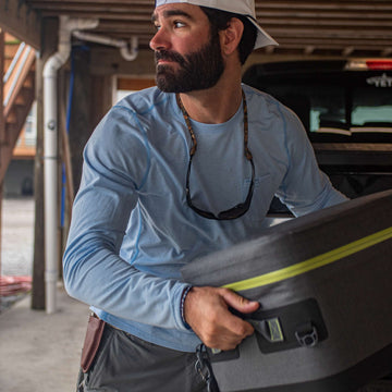 man carrying cooler wearing sky blue crewneck
