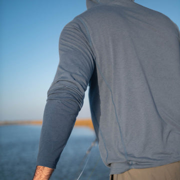 man fishing wearing slate blue hoodie