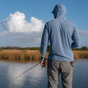 man fishing wearing slate blue hoodie