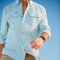 close up image of man's body wearing green and white checkered performance fishing shirt (long sleeve)