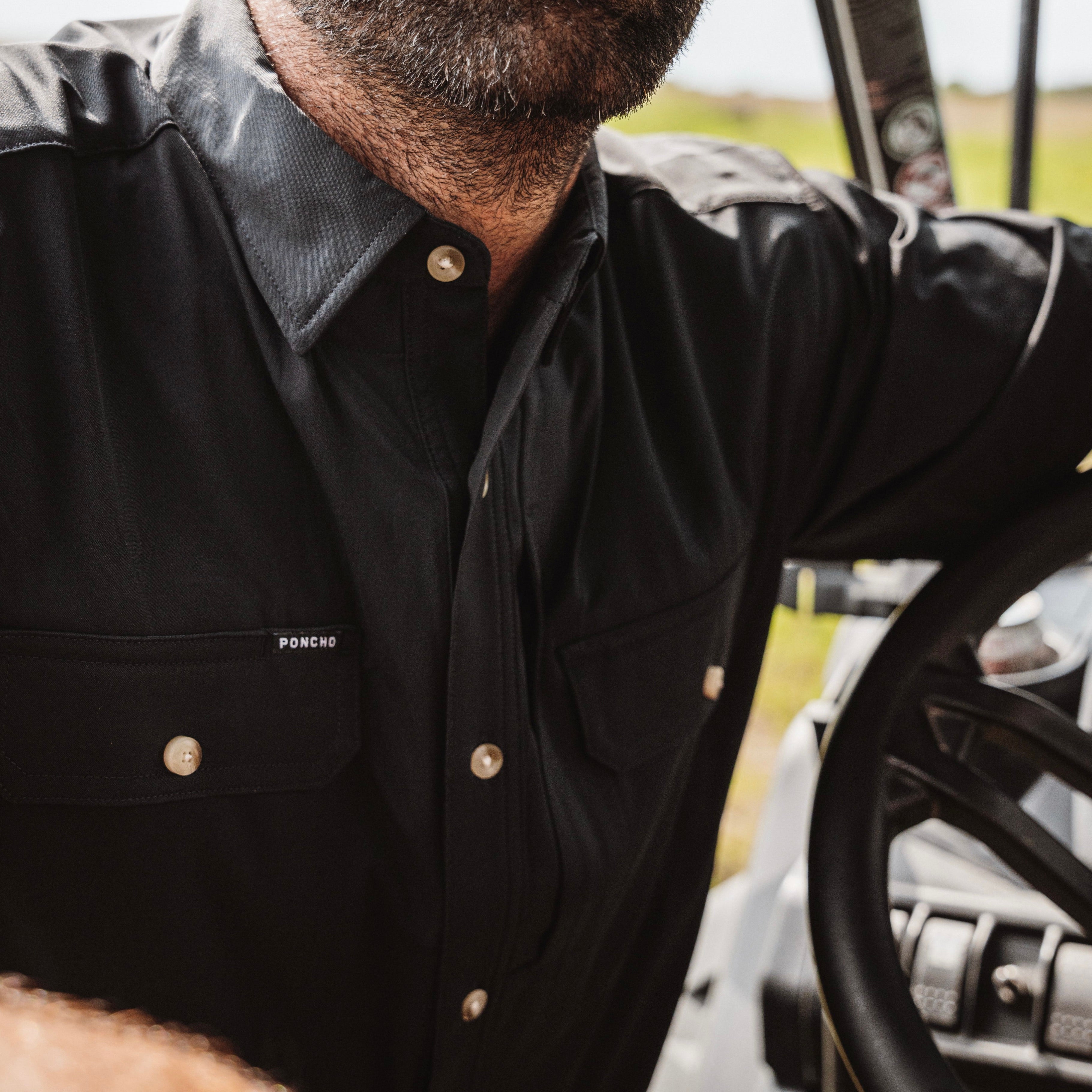 Close up photo of man's chest area highlighting a black short sleeve performance fishing shirt