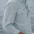 Side view of man wearing teal checkered long sleeve shirt
