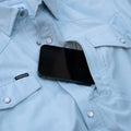 phone in zip pocket in light blue short sleeve pearl snap shirt
