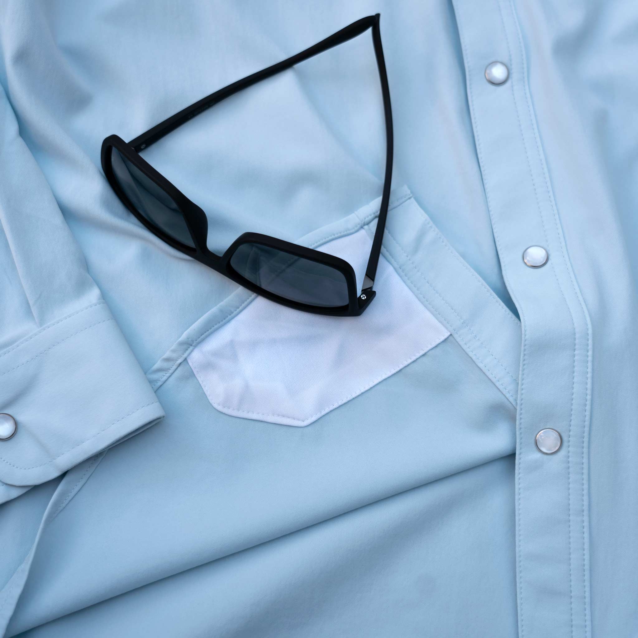 lens cloth on light blue long sleeve pearl snap shirt