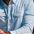 closeup of chest on light blue long sleeve pearl snap shirt