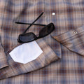 close up of lens cloth on brown blue plaid shirt