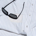Picture of sunglasses on top of lens cloth on striped western shirt