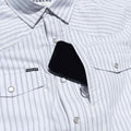 Close up of phone going into pocket of striped shirt