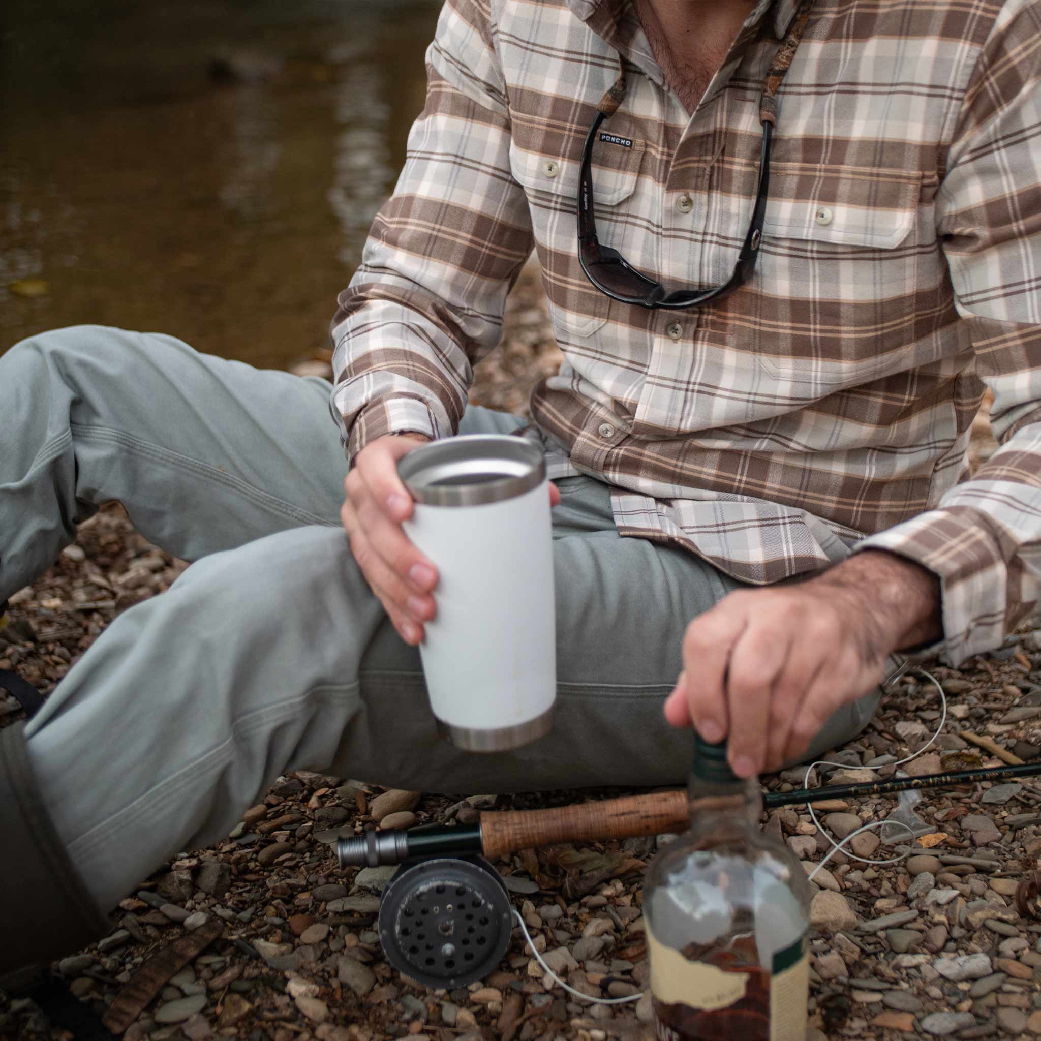 man prepares for a refill while wearing brown and grey plaid long sleeve flannel