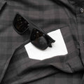 Close up lens of sunglasses on top of underside of shirt