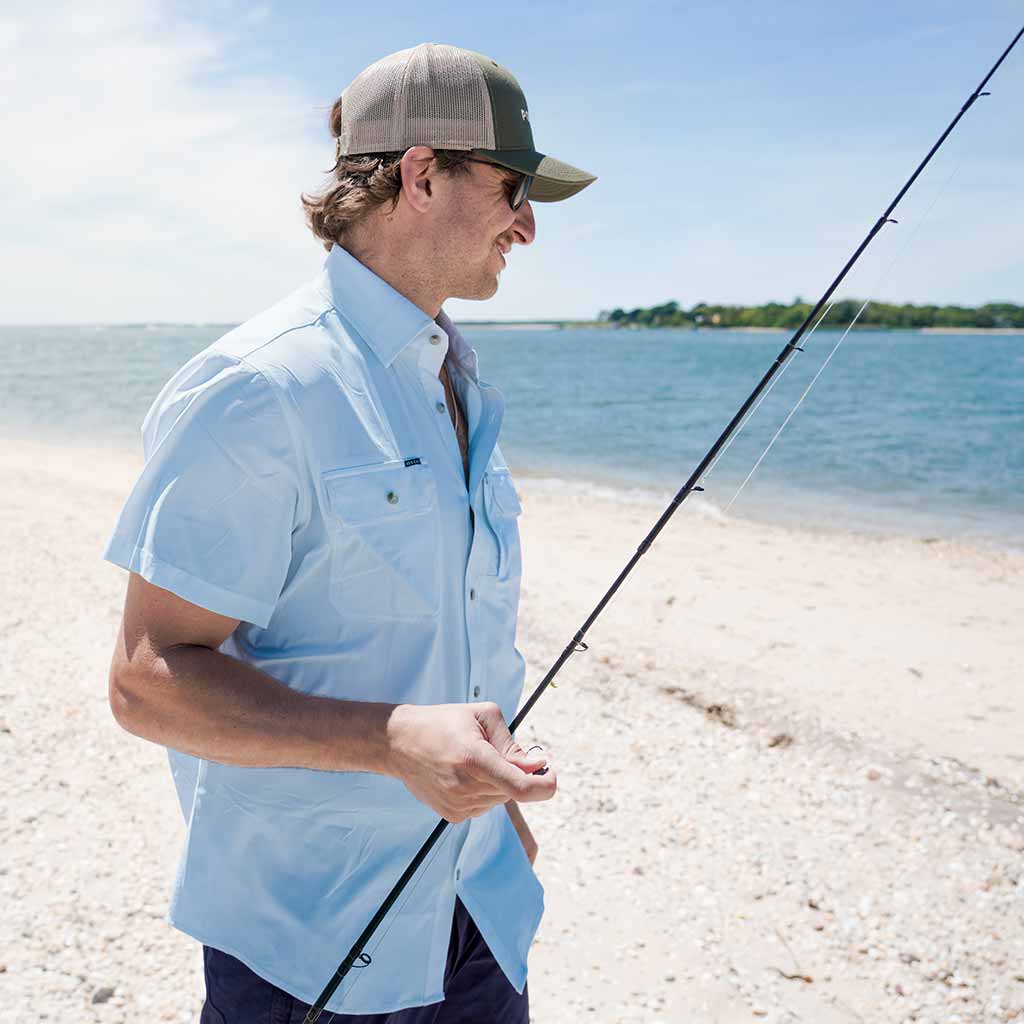 man in blue shirt with fishing rod