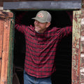 guy wearing red plaid shirt in barn door frame