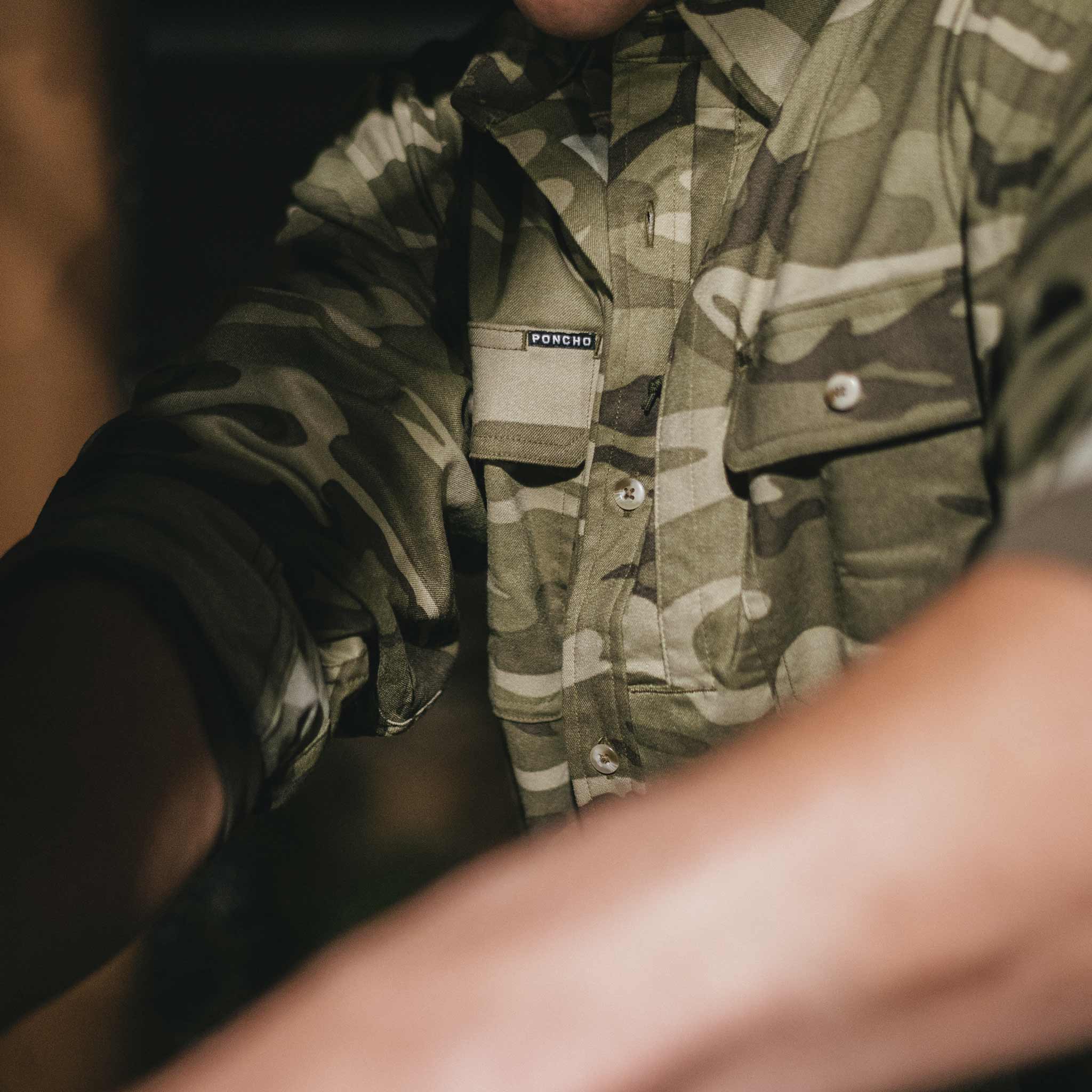 close up of man wearing camo long sleeve shirt with sleeves rolled up