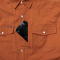 Picture of a phone going into the burnt orange zipper chest pocket