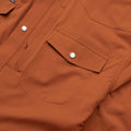 Close up of the pearl snap pockets on the burnt orange shirt