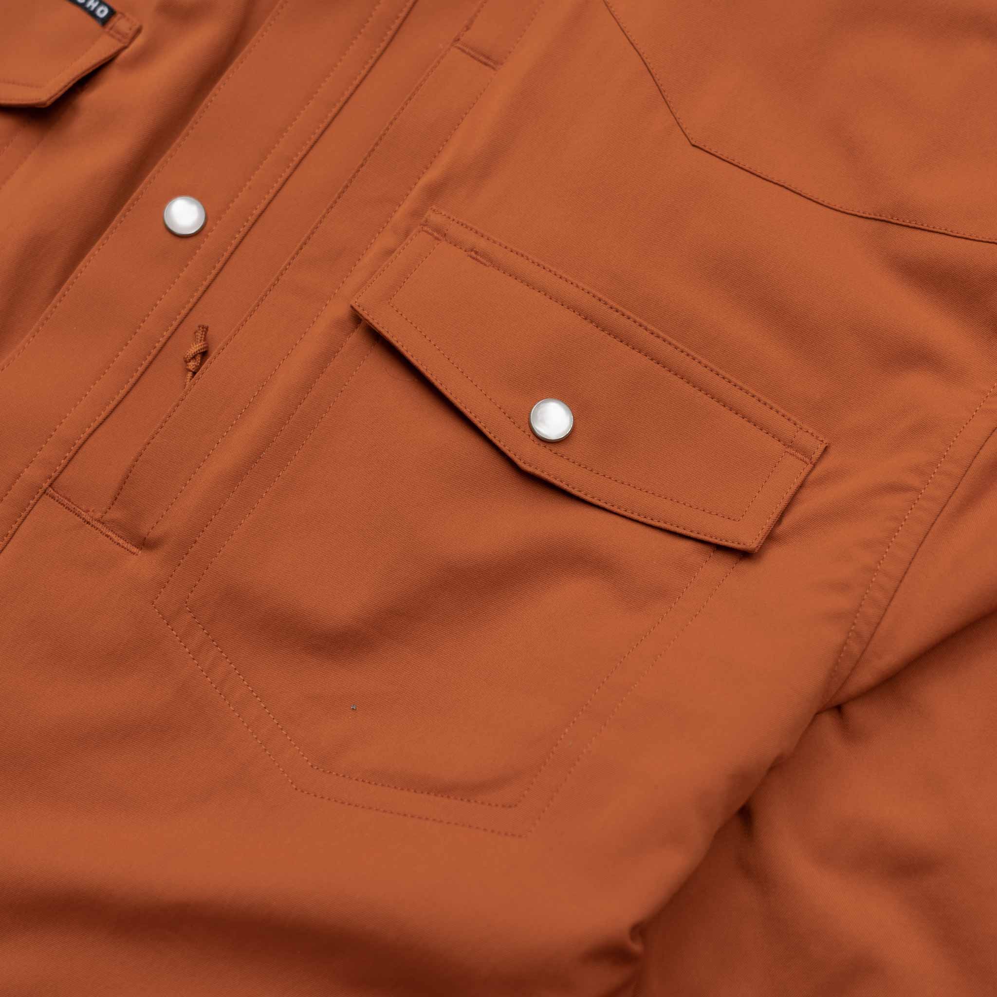 Close up of the burnt orange chest pocket with pearl snaps