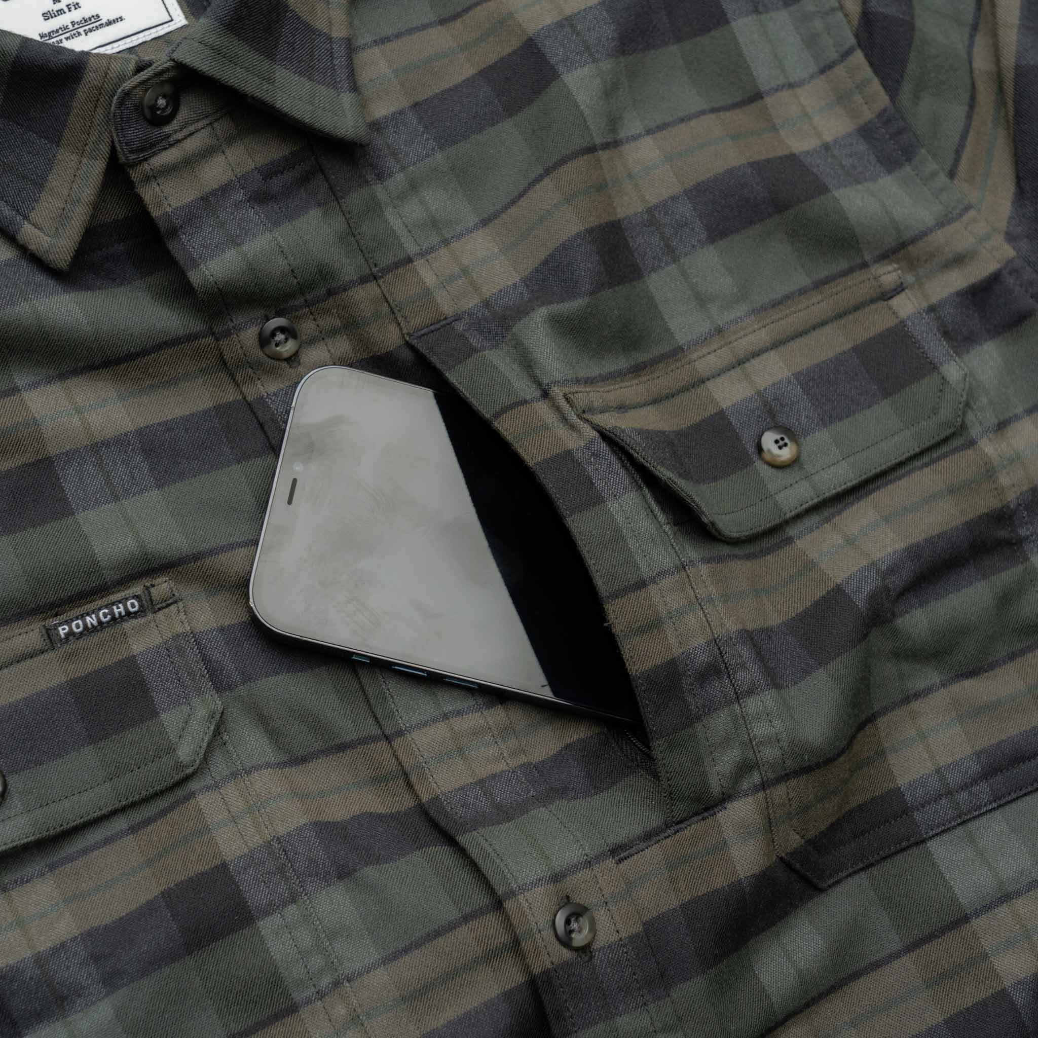 Close up of a phone going inside of the chest zipper pocket on the Kodiak plaid flannel