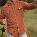 Close up of man with fishing rod wearing the burnt orange long sleeve shirt.