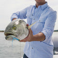 Man in blue plaid shirt with fish 