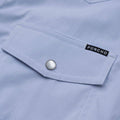Close up photo of chest pocket of the blue microcheck shirt with pearl snap buttons