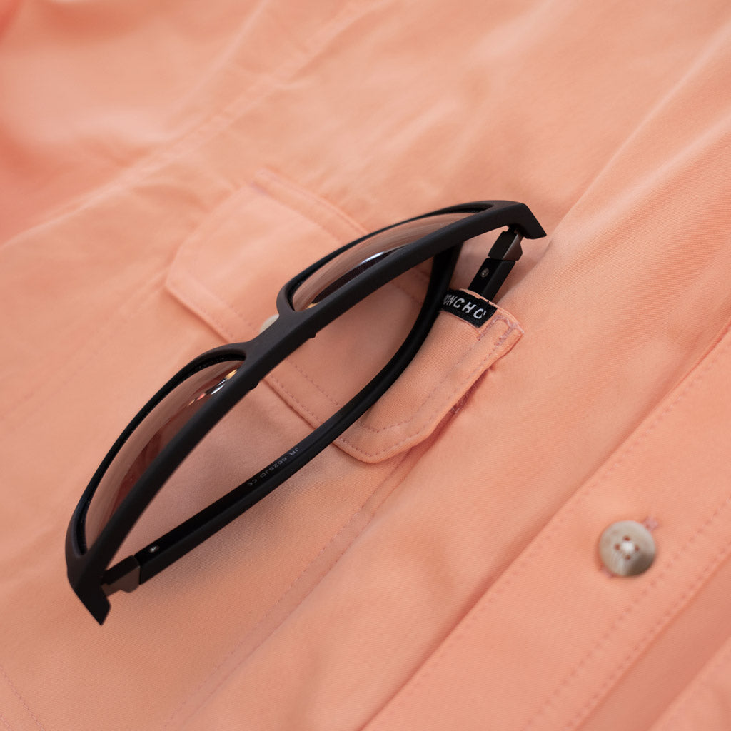 light orange long sleeve fishing shirt sunglasses close up