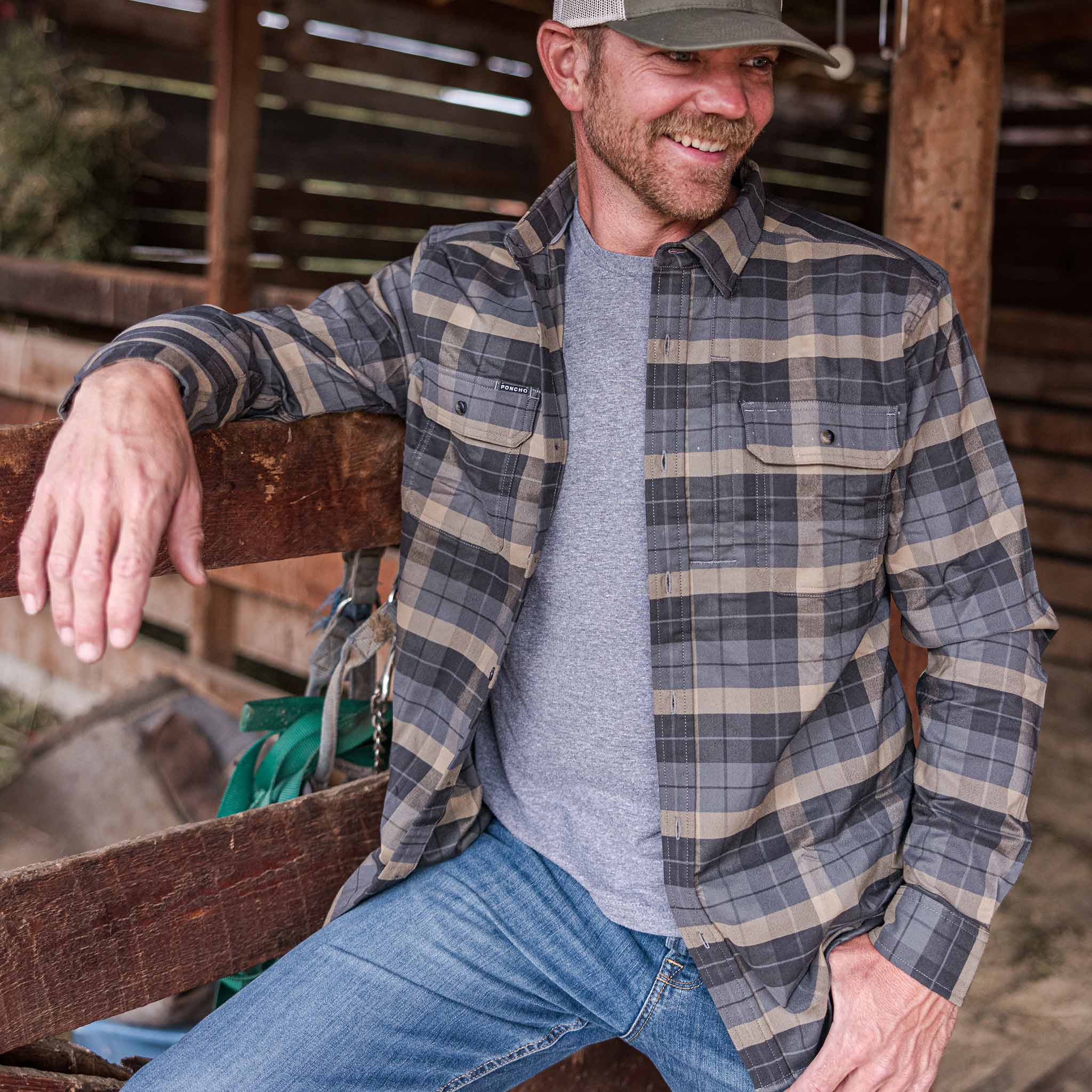 guy wearing flannel standing in barn