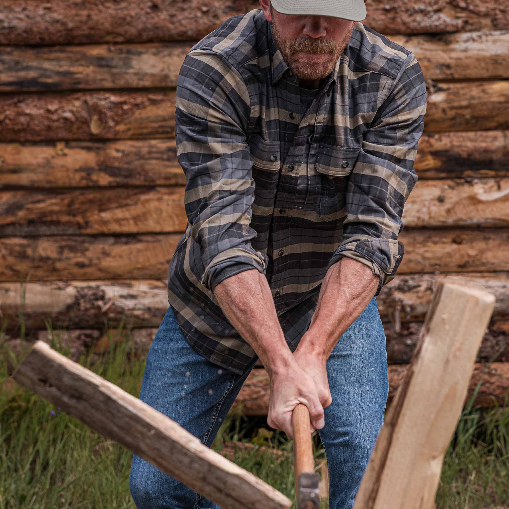 guy wearing flannel chopping wood